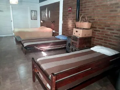 a bedroom with two beds and a brick wall at Rincón de Nina in Tanti