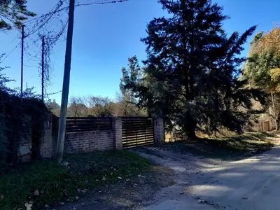 a fence and a tree next to a street at Rincón de Nina in Tanti