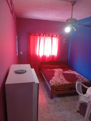 a bedroom with a red bed and a table in a room at Albricias in Mina Clavero