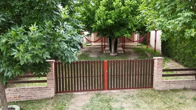 a red fence with a tree behind it at Cabañas Don Lelio in Mina Clavero
