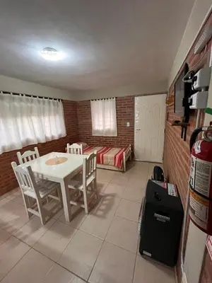 a room with a table and chairs and a couch at Cabañas Don Lelio in Mina Clavero