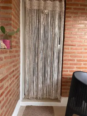 a window with a metal curtain in a brick wall at Cabañas Don Lelio in Mina Clavero