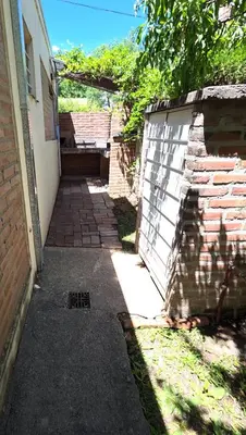 a walkway next to a brick building with a fence at Cabañas Don Lelio in Mina Clavero