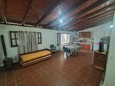 a room with a bed and a table and chairs at Complejo los lirios in Villa Los Aromos