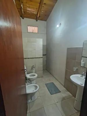 a bathroom with two toilets and a sink at Complejo los lirios in Villa Los Aromos