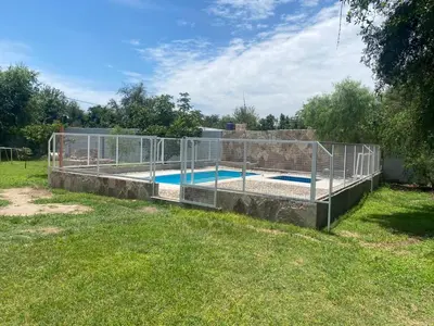 a metal fence around a swimming pool in a yard at Complejo los lirios in Villa Los Aromos