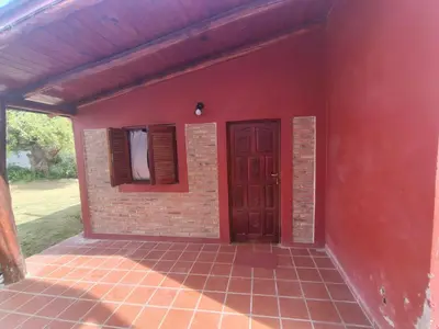 a red house with a door and a window at Complejo los lirios in Villa Los Aromos