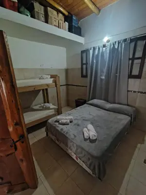 a bedroom with a bed with flip flops on it at Complejo los lirios in Villa Los Aromos