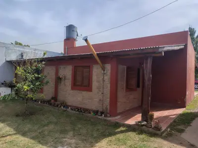 a red brick house with a red roof at Complejo los lirios in Villa Los Aromos