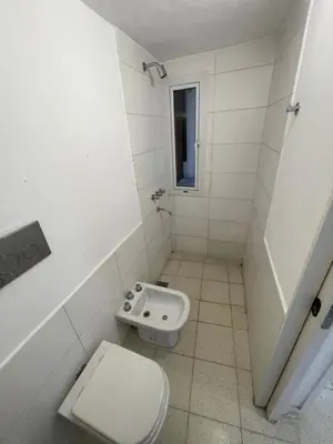 a white bathroom with a toilet and a sink at La Casa de la Colina in Cordoba