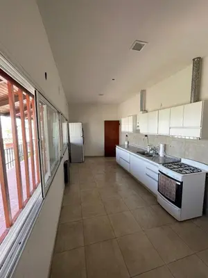 a large kitchen with white cabinets and a large window at La Casa de la Colina in Cordoba
