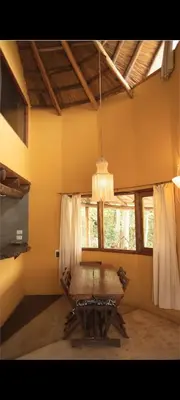 a dining room with a table and a chandelier at Cabañas Bendita Tierra- Crespin in Los Molles