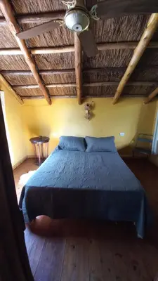 a bedroom with a blue bed with a wooden ceiling at Cabañas Bendita Tierra- Crespin in Los Molles
