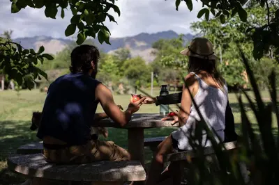 a man and a woman sitting at a picnic table at Cabañas Bendita Tierra - Calandrias in Los Molles