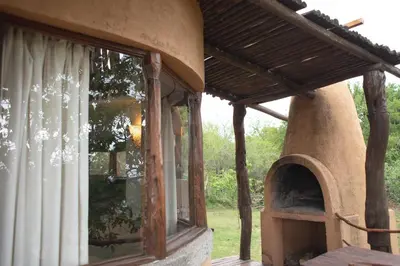 an outdoor pizza oven in a house with a window at Cabañas Bendita Tierra - Calandrias in Los Molles
