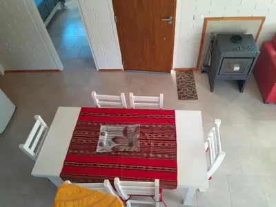 a table and chairs in a room with a stove at Aire Serrano in Los Reartes