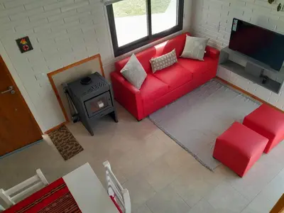 an overhead view of a living room with a red couch and a stove at Aire Serrano in Los Reartes