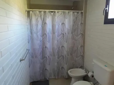 a bathroom with a shower curtain with a toilet at Aire Serrano in Los Reartes