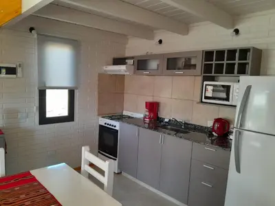 a kitchen with a white refrigerator and a table in it at Aire Serrano in Los Reartes