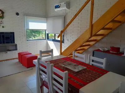 a room with a table and chairs and a staircase at Aire Serrano in Los Reartes
