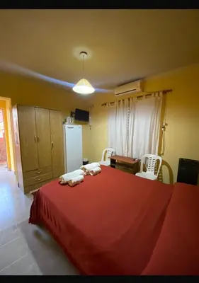 a bedroom with a red bed with towels on it at sukkah in Santa Rosa de Calamuchita