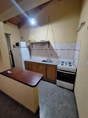 a small kitchen with a stove and a refrigerator at sukkah in Santa Rosa de Calamuchita
