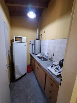 a kitchen with a white refrigerator and a sink at sukkah in Santa Rosa de Calamuchita