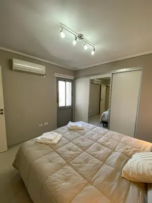 a bedroom with a large bed with two towels on it at Departamento 2 dor Calidad seguridad 24h complejo cerrado in Cordoba