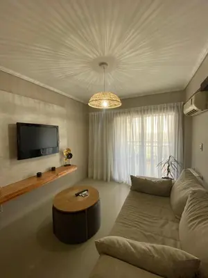 a living room with a couch and a flat screen tv at Departamento 2 dor Calidad seguridad 24h complejo cerrado in Cordoba