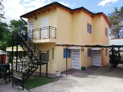 a yellow house with a spiral staircase in front of it at Lodemarta in Villa Carlos Paz