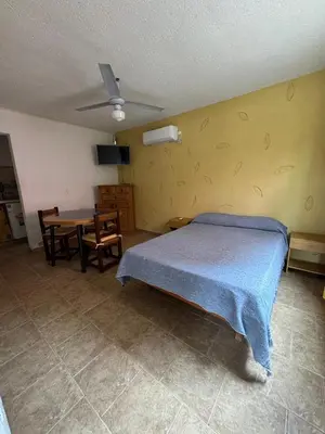a bedroom with a bed and a table in it at Lodemarta in Villa Carlos Paz