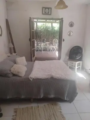 a bedroom with a bed and a window with a table at Casa de campo con pileta in Alta Gracia