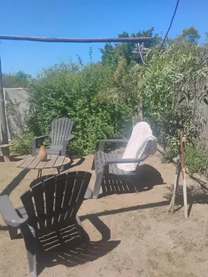 two chairs and a table in a yard at Casa de campo con pileta in Alta Gracia