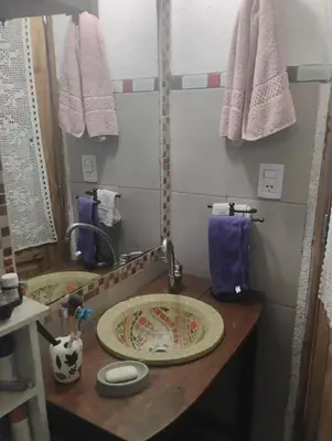 a bathroom with a counter with a sink and towels at Casa de campo con pileta in Alta Gracia