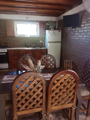 a kitchen with a table with chairs and a refrigerator at Tanti casita del rio in Tanti Nuevo