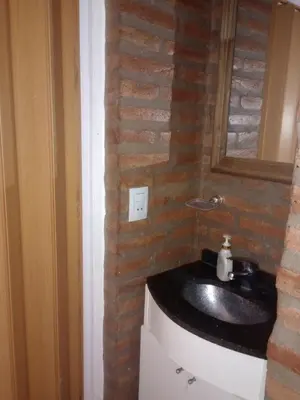 a bathroom with a sink and a brick wall at Tanti casita del rio in Tanti Nuevo