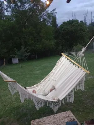 a baby sleeping in a hammock in a yard at Tanti casita del rio in Tanti Nuevo