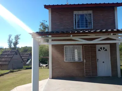 a large brick house with a white door at Tanti casita del rio in Tanti Nuevo