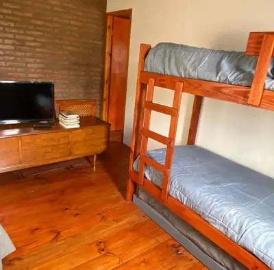 a room with two bunk beds and a desk at Tanti casita del rio in Tanti Nuevo