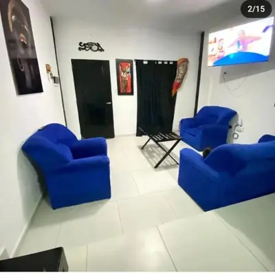 a living room with blue chairs and a screen at Doña LoIa in San Roque