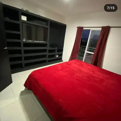 a bedroom with a red bed and a window at Doña LoIa in San Roque