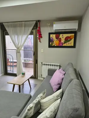 a living room with a gray couch and a table at No disponible in Río Cuarto