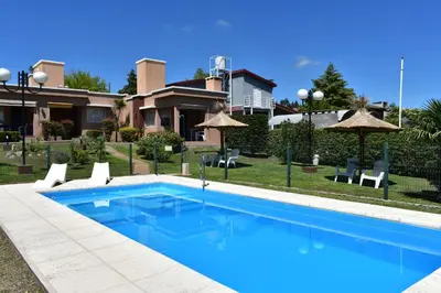 a swimming pool in front of a house at Aparts Solares in San Antonio de Arredondo