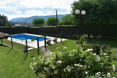 a swimming pool in a yard with flowers and plants at Aparts Solares in San Antonio de Arredondo