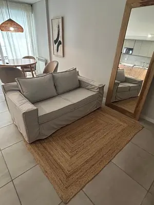 a living room with a couch and a mirror at Departamento Premium con Pileta en Altura in Cordoba