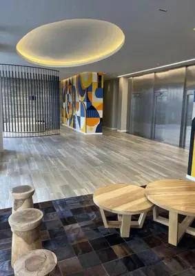 a lobby with wooden tables and benches and a yellow ceiling at Departamento Premium con Pileta en Altura in Cordoba