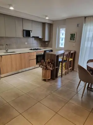 a large kitchen with a table and chairs in it at Departamento Premium con Pileta en Altura in Cordoba