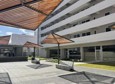 a building with two umbrellas in a courtyard at Departamento Premium con Pileta en Altura in Cordoba