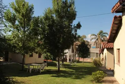 a yard with a table and chairs and trees at Bungalows Aguas Claras in Villa del Dique