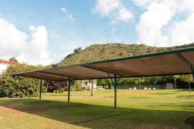 a large green pavilion with a hill in the background at Bungalows Aguas Claras in Villa del Dique